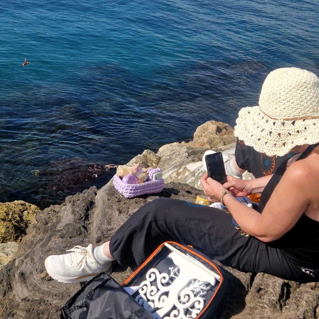 Natalia, de Jabones Mami, fotografiando sus productos sobre las rocas junto al mar