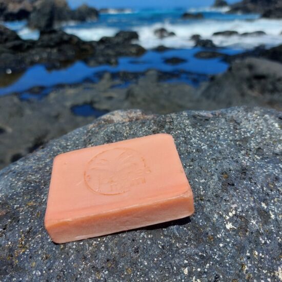Pastilla de jabón natural de Jabones Mami sin envoltorio sobre una roca junto al mar